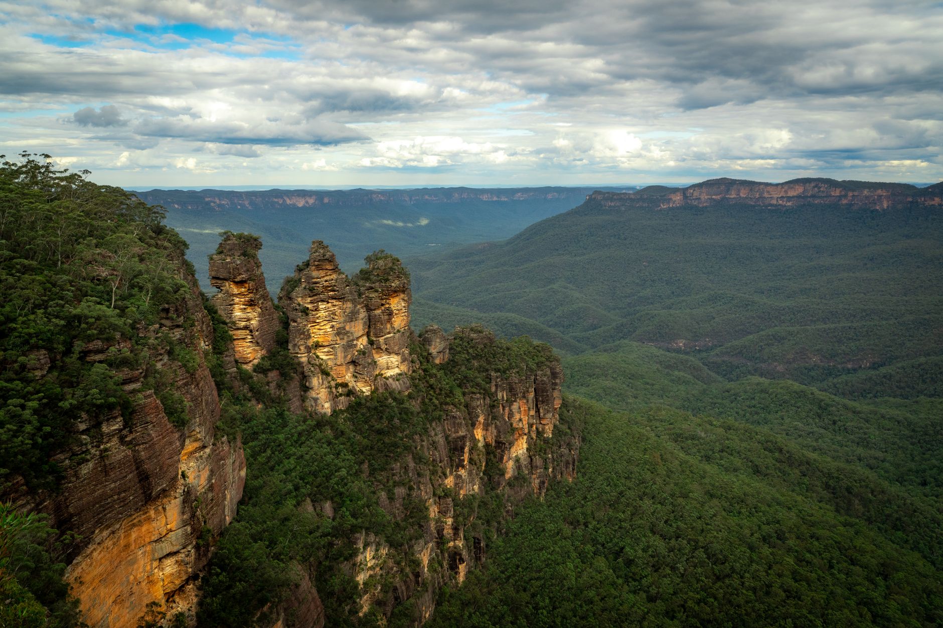 Formación rocosa Three Sisters en las Blue Mountains, con un valle verde al fondo