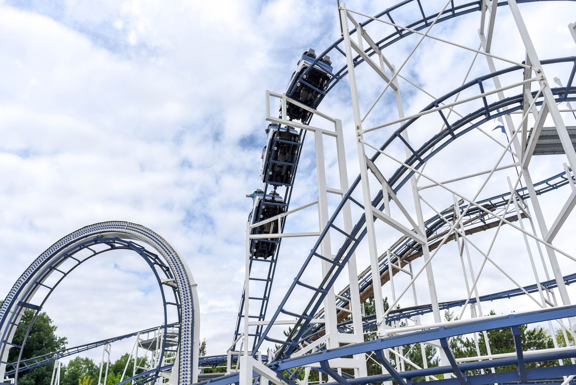 Roller coaster in motion against a cloudy sky