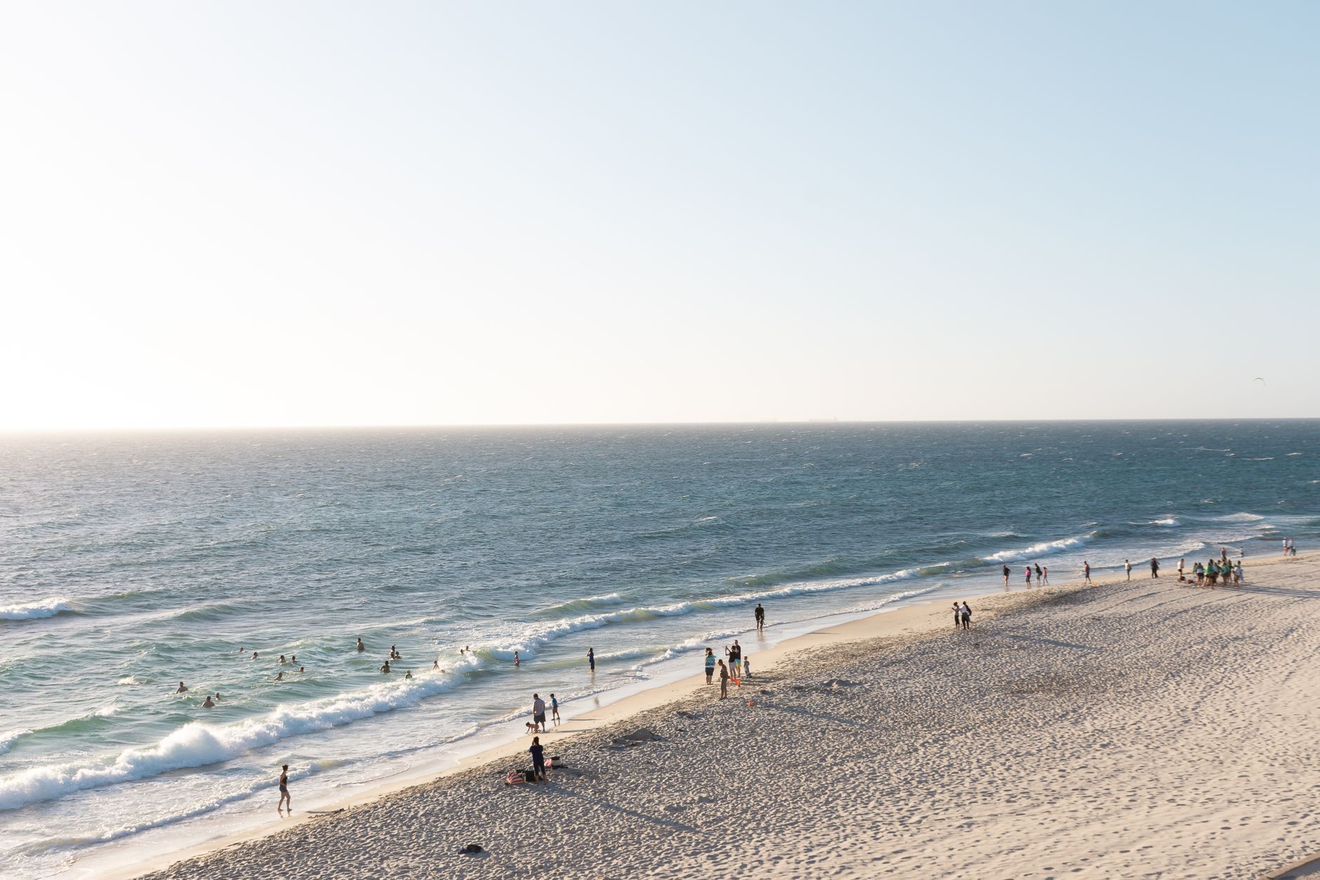 Perth beach with people on the sand and in the sea, late afternoon