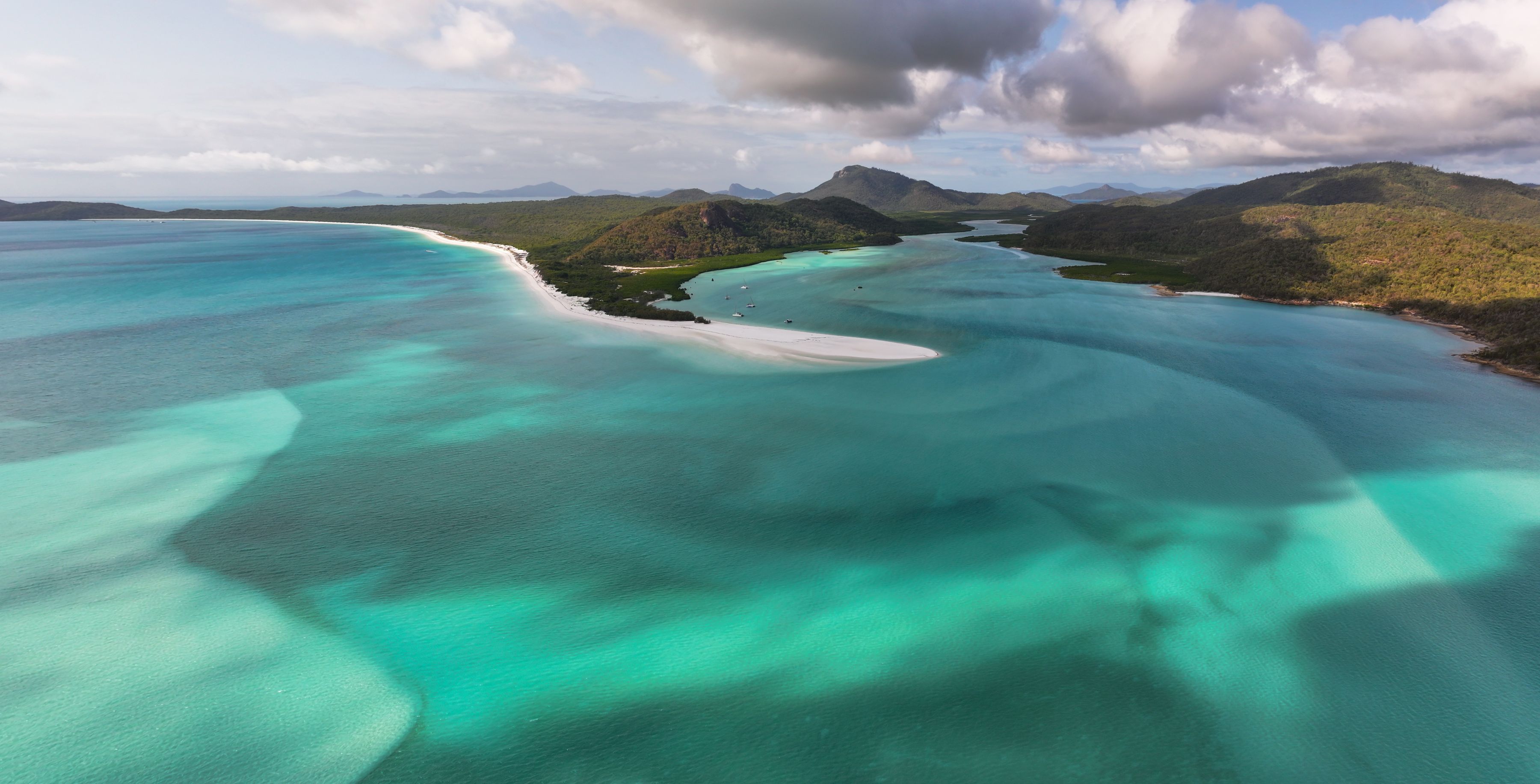 Aerial view of Hill Inlet, with the swirl pattern between white sand and turquoise water between Whitsunday Island and the sea